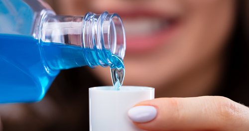 woman pouring mouthwash