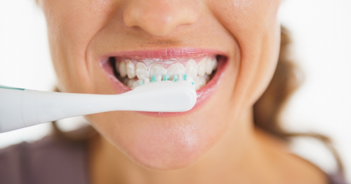 woman brushing teeth as part of her oral care cleaning techniques